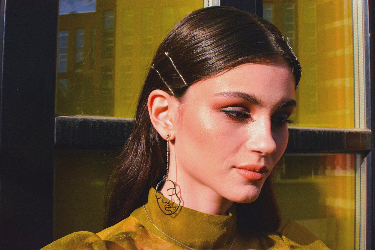 Close-up portrait of a woman showcasing unique earrings and elegant style.